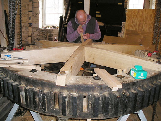 Millwright John O’Rourke is seen working in 2009 on elements of the “spur gear,” which helps transfer the energy of the water wheel to the millstones.