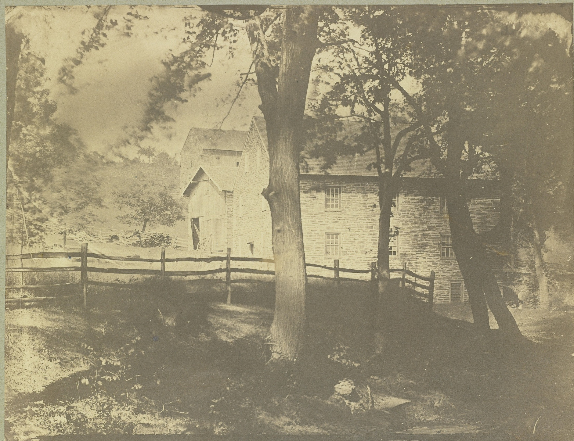 Very old black and white photograph of Peirce Mill with the barn in the distance. Handwritten caption
