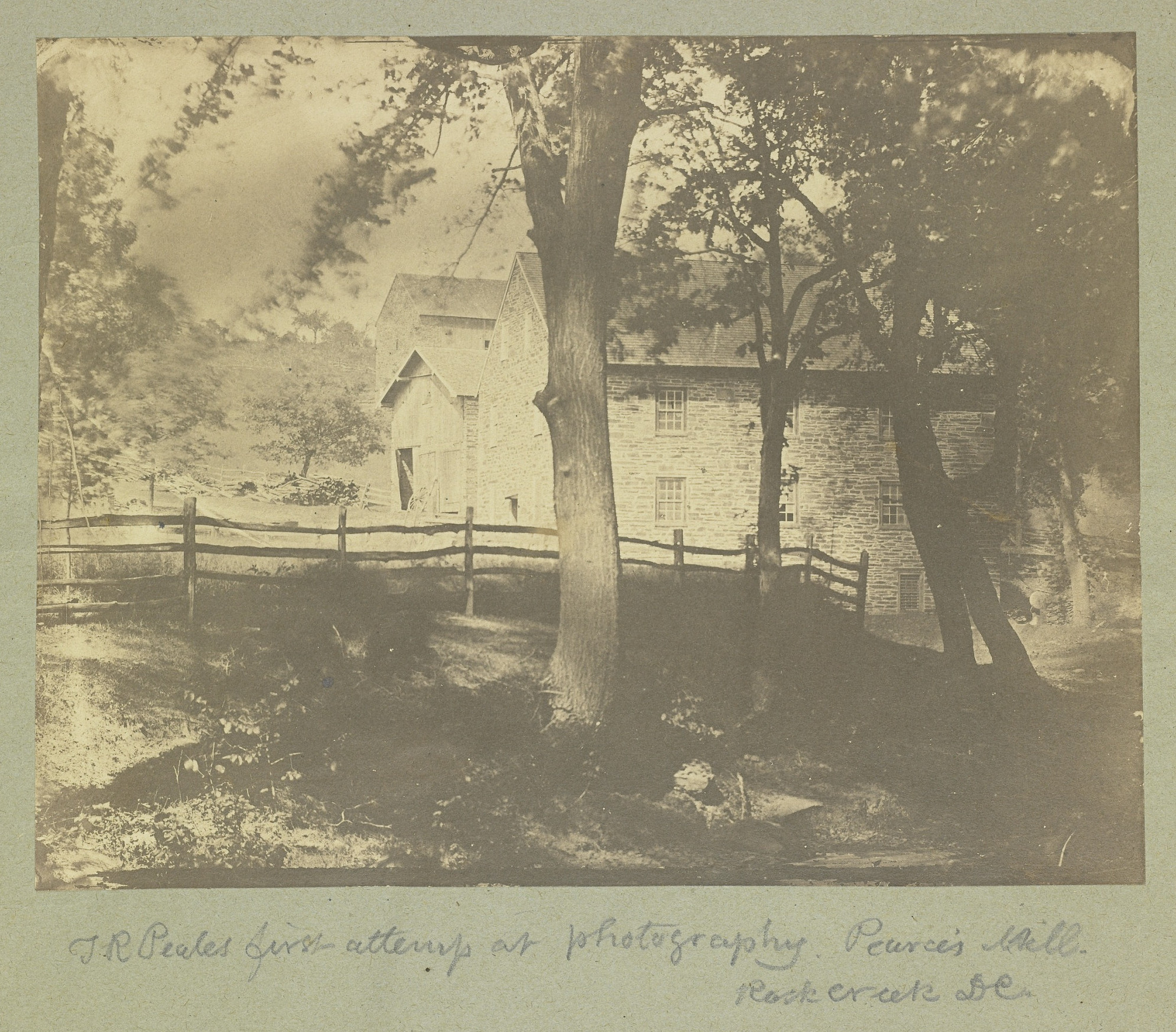 Very old sepia-toned photograph of Peirce Mill with two stone barns in distance.