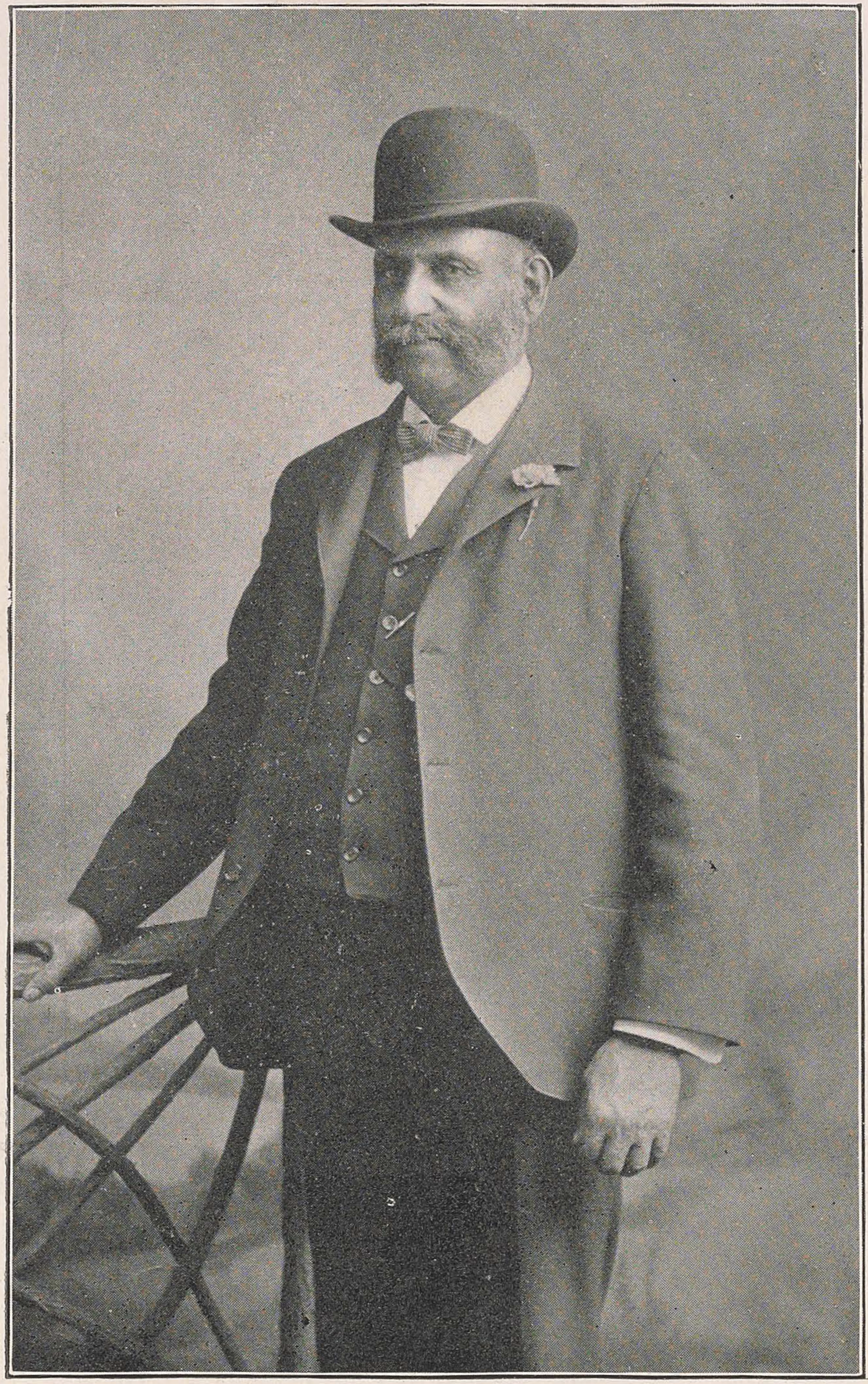 Old black and white photograph of a distinguished looking older man with a bowler hat and bushy whiskers.