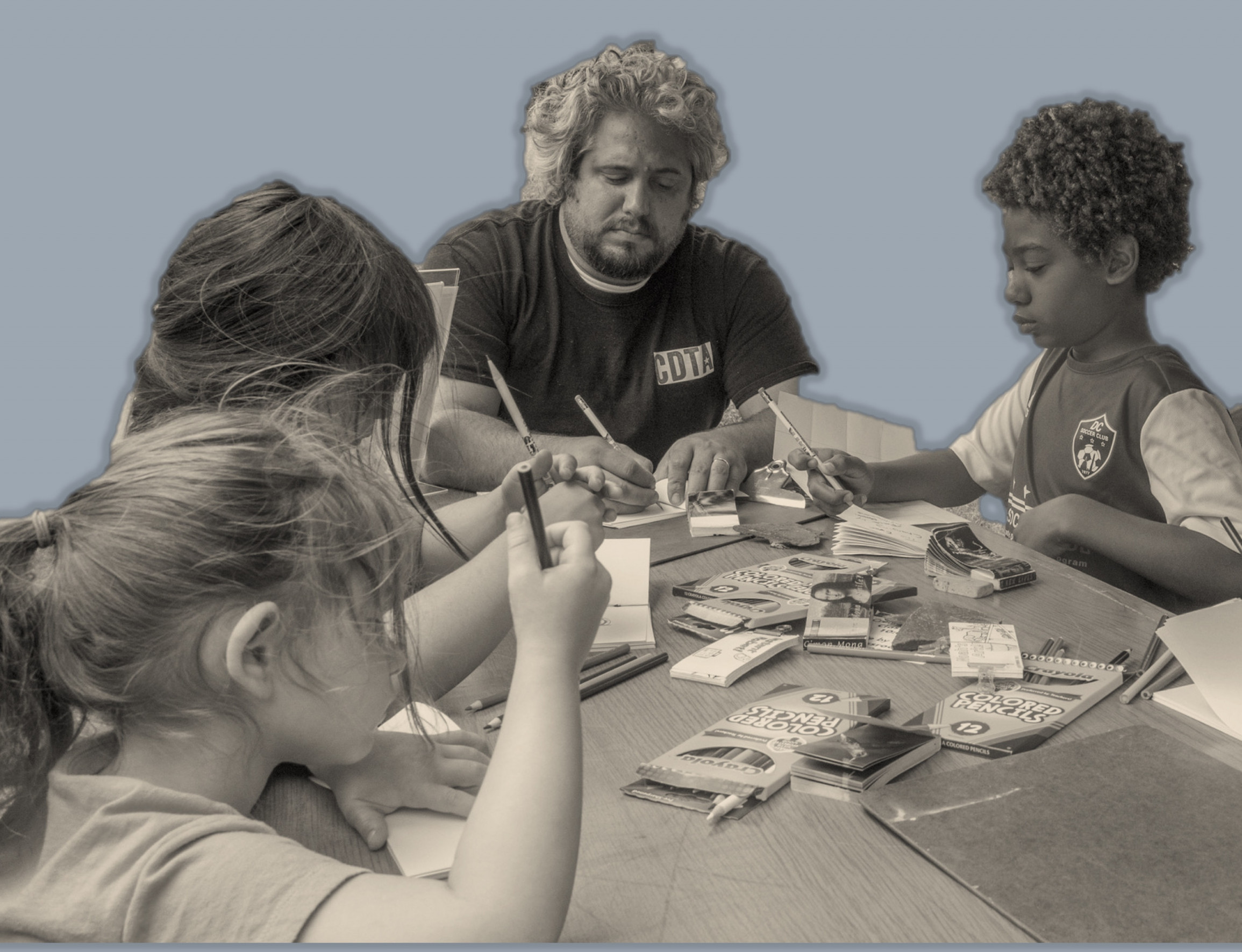 Family works together on art project using colored pencils and paper.