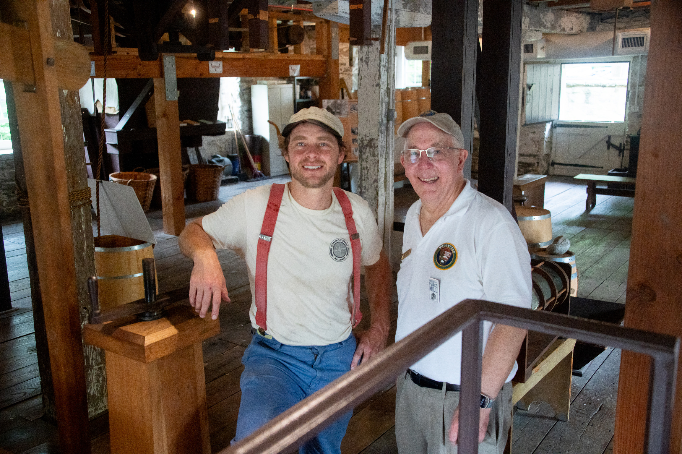 A miller stands next to a man in a National Park Service volunteer uniform