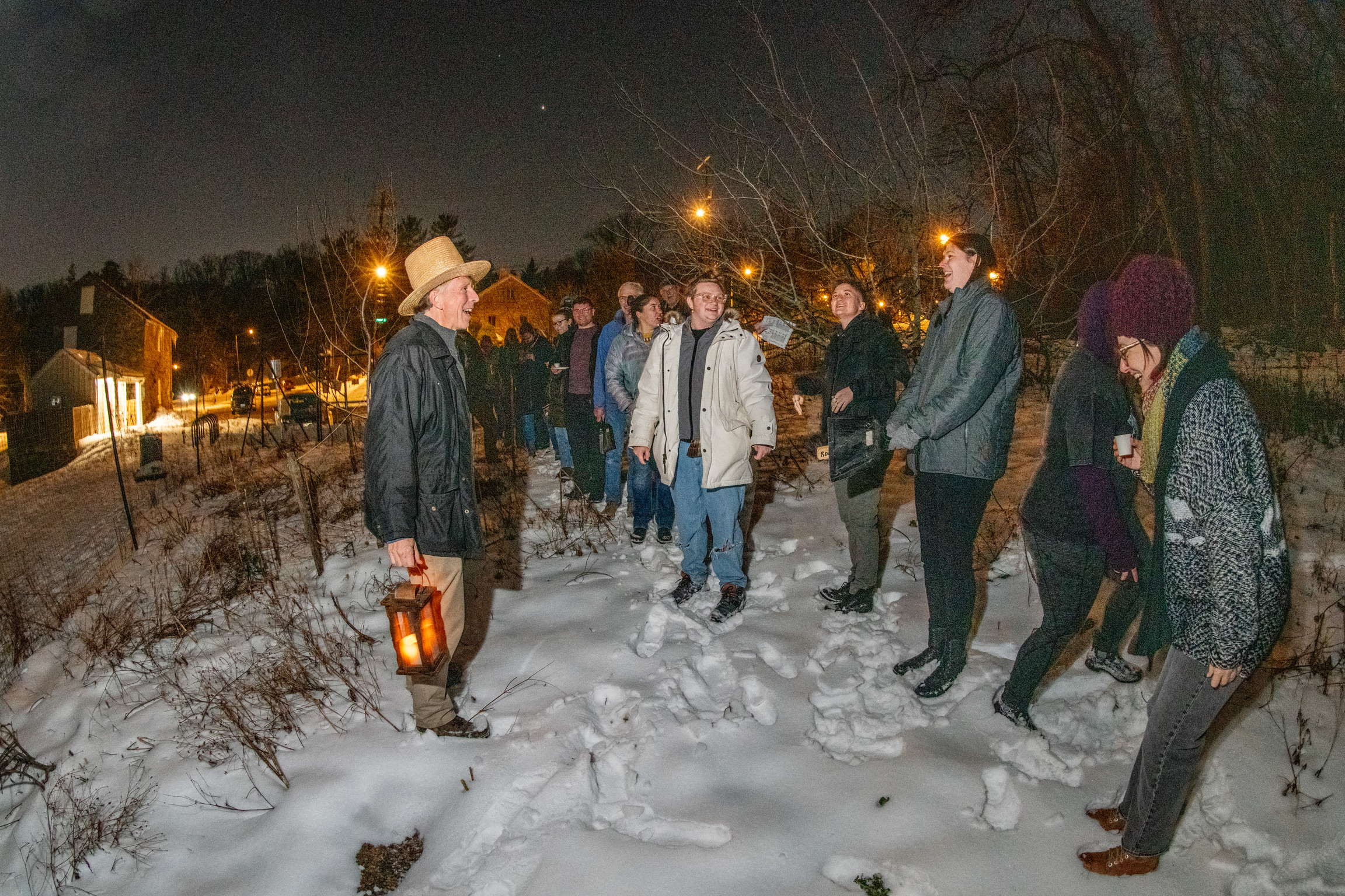 People stand in a snowy orchard, celebrating