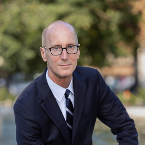 Man in a suit sitting on a bench on a city street