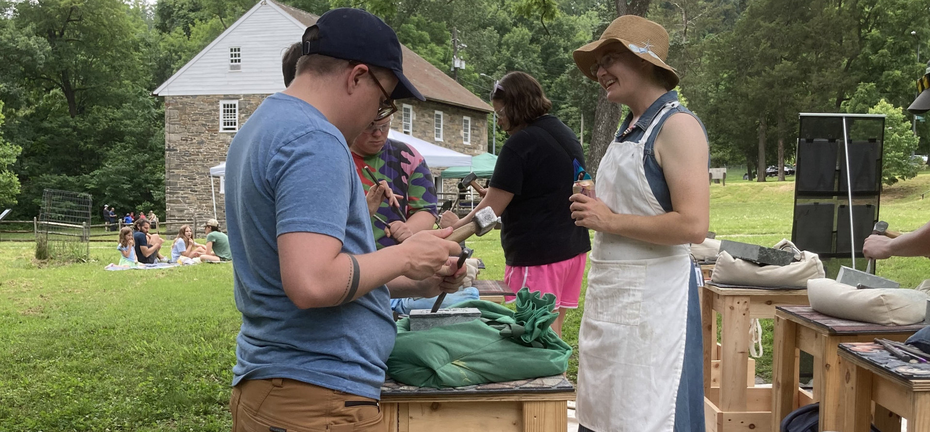 A group of people carve stones in a public park.
