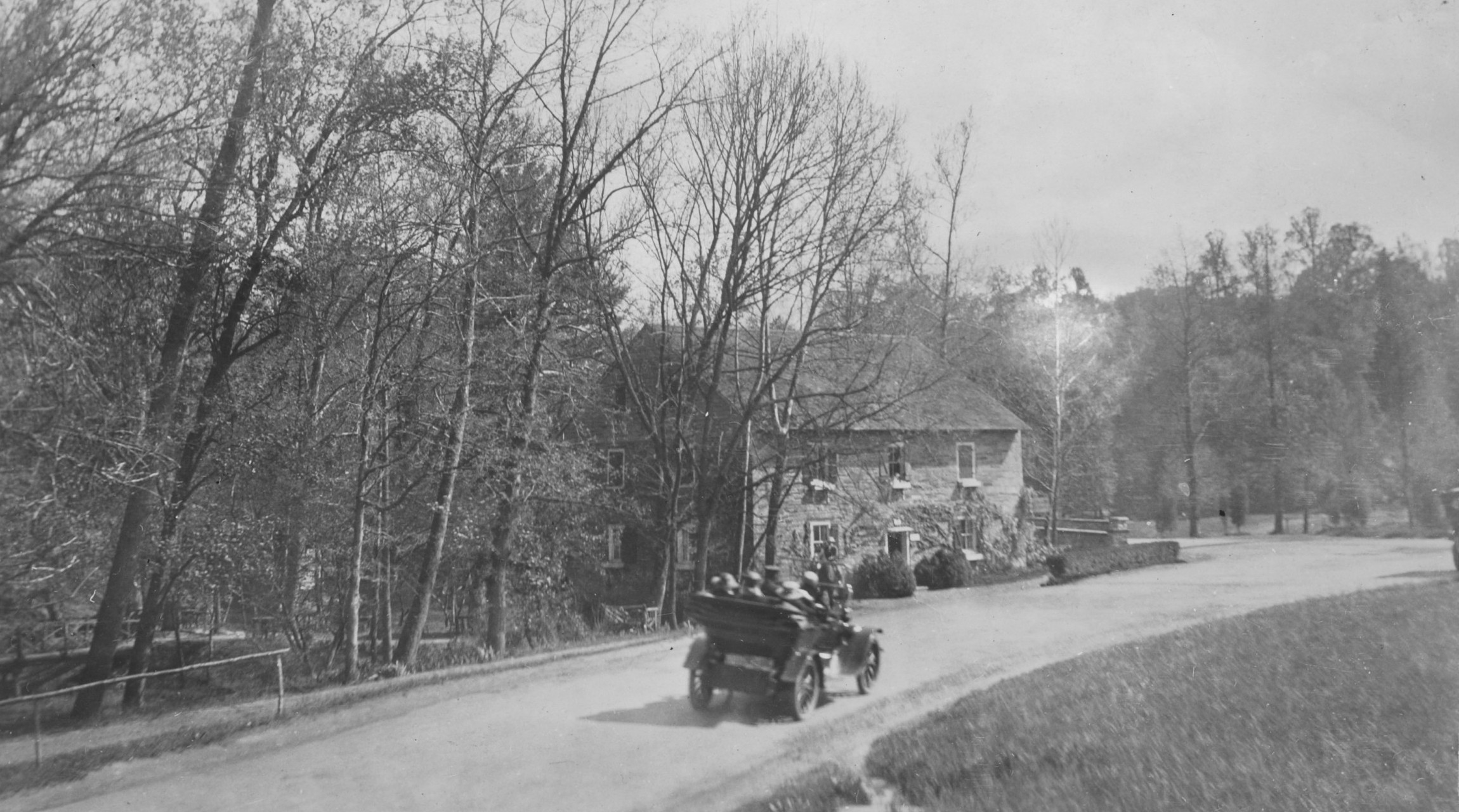 Old black and white photograph of early automobile driving toward Peirce Mill