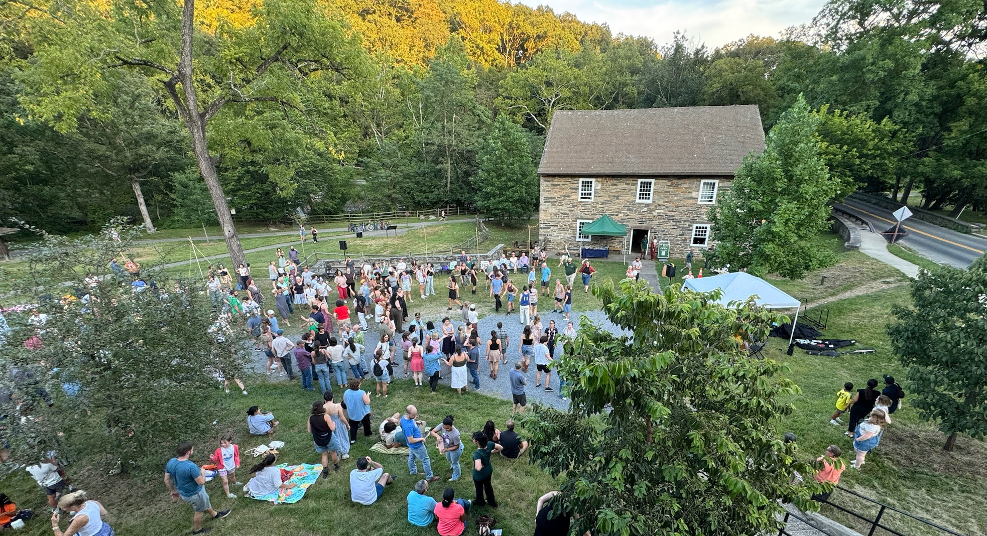 People dancing in front of an historic stone mill