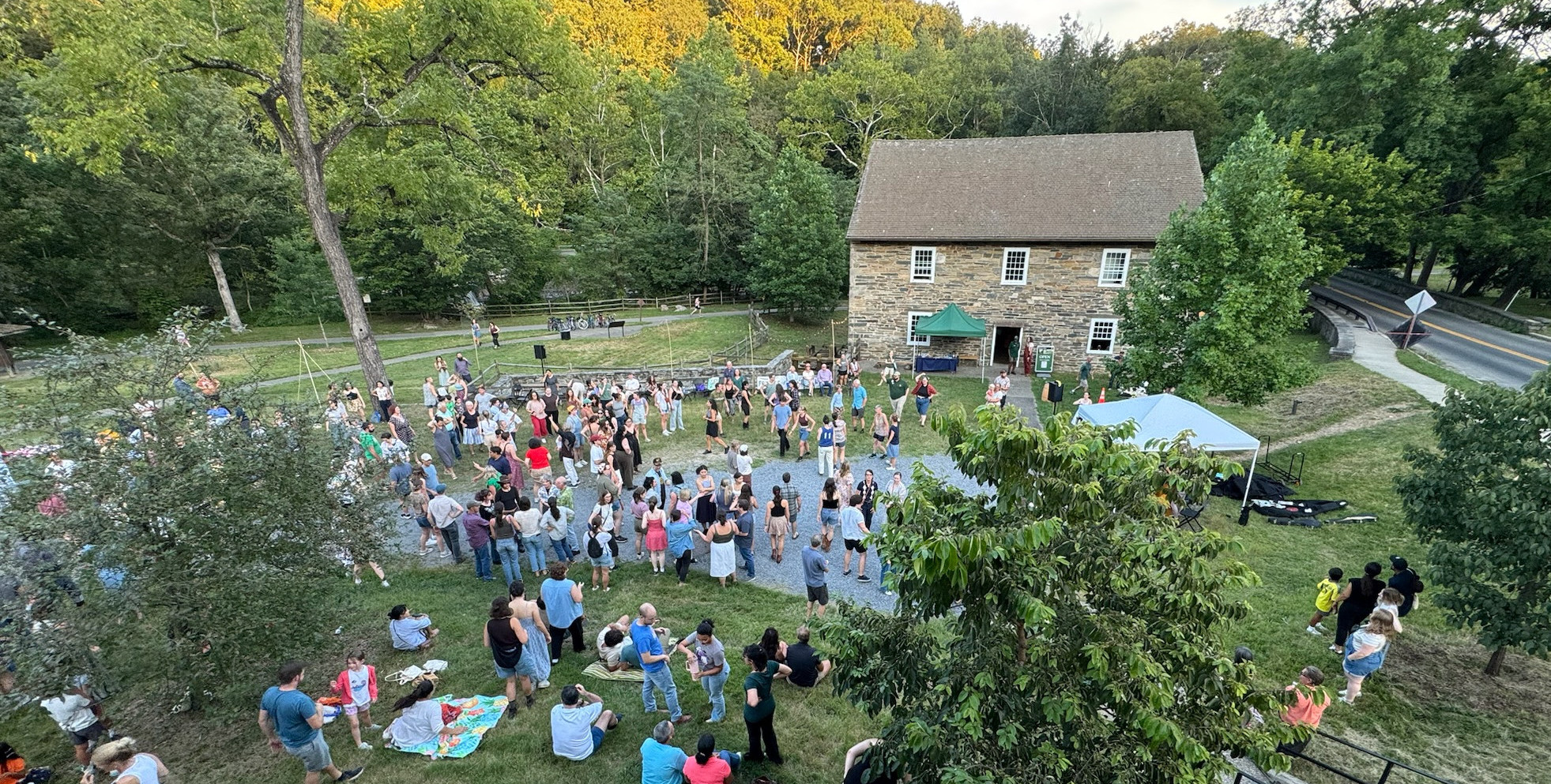 People dancing in front of an historic stone mill